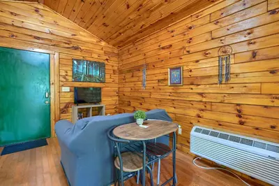 a living room with a blue couch and a table at Blue Rose Cabins - Sweet Dreams Cabin in Logan