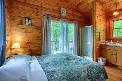 a bedroom with a bed in a log cabin at Blue Rose Cabins - Sweet Dreams Cabin in Logan