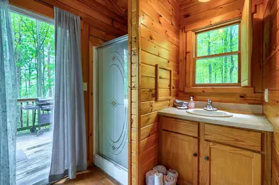 a bathroom with a sink and a window in a cabin at Blue Rose Cabins - Sweet Dreams Cabin in Logan