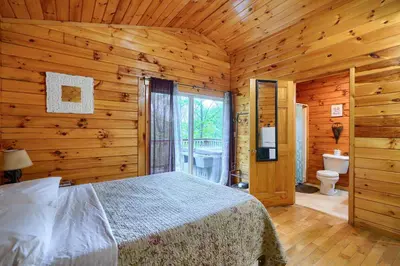 a bedroom with a bed in a wooden cabin at Blue Rose Cabins - Treetops Cabin in Logan