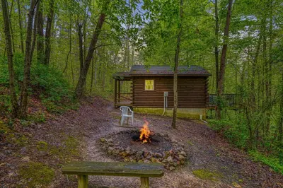 a log cabin with a fire in front of it at Blue Rose Cabins - Wildwoods Cabin in Logan
