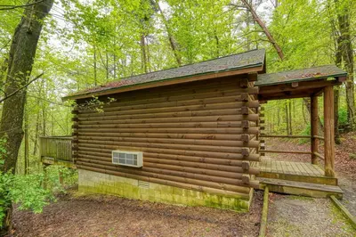 a log cabin in the woods with a window at Blue Rose Cabins - Wildwoods Cabin in Logan