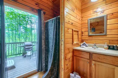 a bathroom with a shower and a sink in a cabin at Blue Rose Cabins - Wildwoods Cabin in Logan