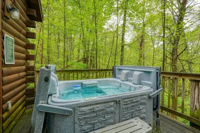 a jacuzzi tub on a deck in the woods at Blue Rose Cabins - Wildwoods Cabin in Logan