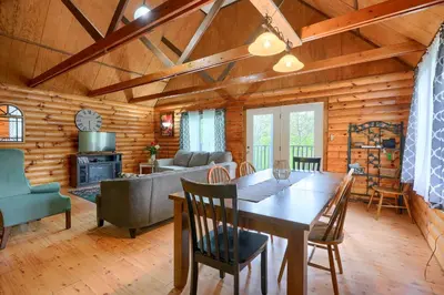 a dining room and living room with a table and chairs at Blue Rose Cabins - Rosewood Cabin in Logan