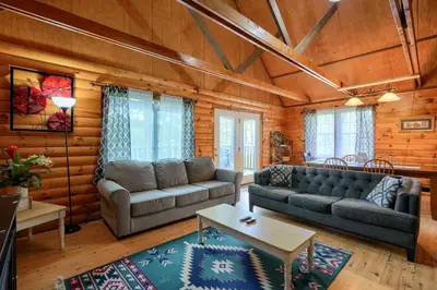 a living room with a couch and a table at Blue Rose Cabins - Rosewood Cabin in Logan