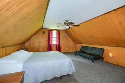 a bedroom with a bed and a ceiling fan at Blue Rose Cabins - Rosewood Cabin in Logan