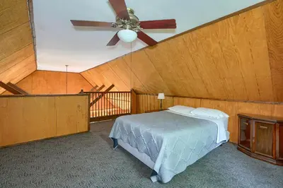 a bedroom with a ceiling fan and a bed at Blue Rose Cabins - Rosewood Cabin in Logan