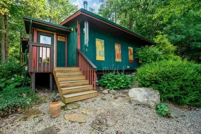 a green and red tiny house in the woods at Beautiful Tiny House, Sauna, Mohican Getaway in Perrysville