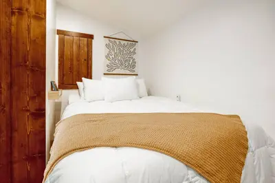 a bedroom with a large white bed with white pillows at Beautiful Tiny House, Sauna, Mohican Getaway in Perrysville