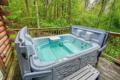 a large outdoor tub sitting on a deck at Blue Rose Cabins - Big Woody Cabin in Logan