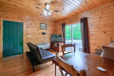 a dining room with a table and a ceiling fan at Blue Rose Cabins - Big Woody Cabin in Logan