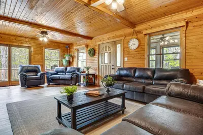 a living room with leather furniture and a table at Family-Friendly Milton Home on 14 Acres with Hot Tub in Milton