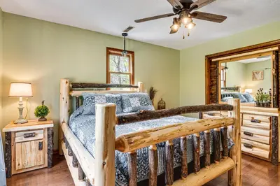 a bedroom with a wooden bed and a mirror at Family-Friendly Milton Home on 14 Acres with Hot Tub in Milton