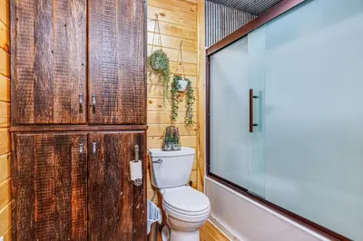 a bathroom with a toilet and a wooden wall at Family-Friendly Milton Home on 14 Acres with Hot Tub in Milton