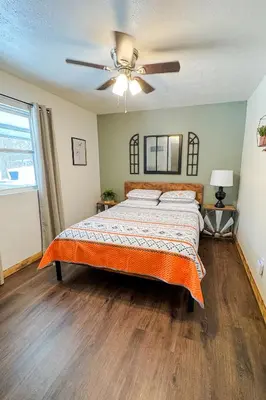 a bedroom with a bed and a ceiling fan at White Oak Cabin in Argillite