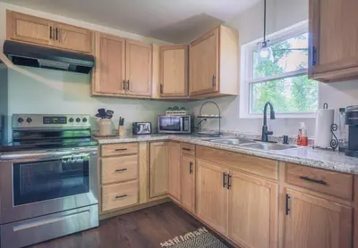 a kitchen with wooden cabinets and stainless steel appliances at White Oak Cabin in Argillite