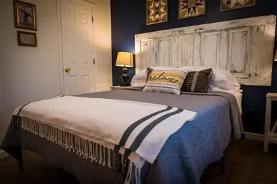 a bedroom with a large bed with a wooden headboard at Hickory House Cabin in Ashley