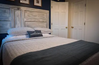 a bedroom with a large bed with a wooden headboard at Hickory House Cabin in Ashley
