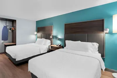 two beds in a hotel room with blue walls at Tru By Hilton Wauseon in Wauseon