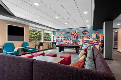 a living room with a couch and a ping pong table at Tru By Hilton Wauseon in Wauseon