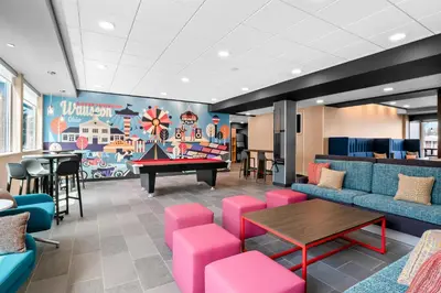 a waiting room with a ping pong table and pink chairs at Tru By Hilton Wauseon in Wauseon