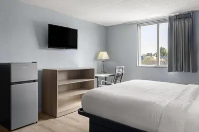 a bedroom with a bed and a desk and a television at Super 8 by Wyndham Fort Wayne in Fort Wayne