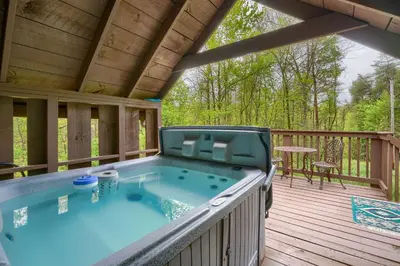 a hot tub on the deck of a cabin at Blue Rose Cabins - Country Cottage in Logan