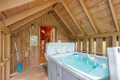 a jacuzzi tub in a wooden house at Blue Rose Cabins - Country Cottage in Logan