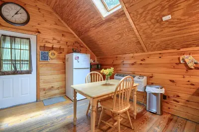 a kitchen with a table and chairs in a cabin at Blue Rose Cabins - Country Cottage in Logan