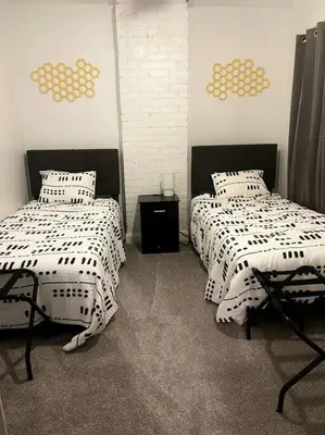 a bedroom with two beds with white and black sheets at Charming Urban Retreat - Near UC, Med Centers, OTR in Cincinnati