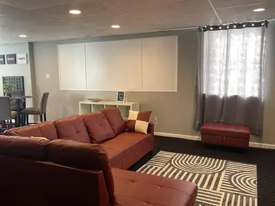 a living room with a brown couch and a table at Charming Urban Retreat - Near UC, Med Centers, OTR in Cincinnati