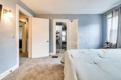 a bedroom with a white bed and a blue wall at Pet-Friendly Cincinnati Apt 5 Mi to Downtown! in Cincinnati