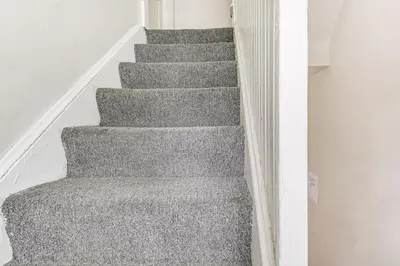 a staircase in a house with grey carpet at Pet-Friendly Cincinnati Apt 5 Mi to Downtown! in Cincinnati