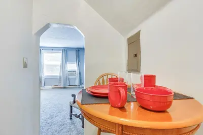 a wooden table with red bowls and plates on it at Pet-Friendly Cincinnati Apt 5 Mi to Downtown! in Cincinnati