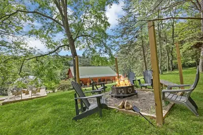 a fire pit in a yard with a dog laying next to it at Spring cabin with Dome, Sauna, Hot Tub, Pickleball, Firepit in Logan