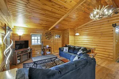 a living room with a blue couch in a log cabin at Spring cabin with Dome, Sauna, Hot Tub, Pickleball, Firepit in Logan