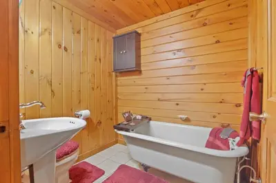 a bathroom with a white tub and wooden walls at Spring cabin with Dome, Sauna, Hot Tub, Pickleball, Firepit in Logan