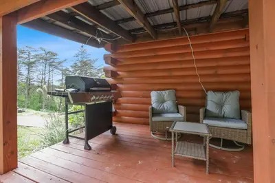 a grill on a deck with two chairs and a table at Spring cabin with Dome, Sauna, Hot Tub, Pickleball, Firepit in Logan
