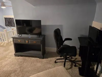 a living room with a television and a chair at Unit 2 at Oilgate at Oakdale in Akron