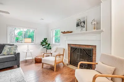a living room with a fireplace and two chairs at Thornville Home with Boat Dock On the Lake! in Hebron