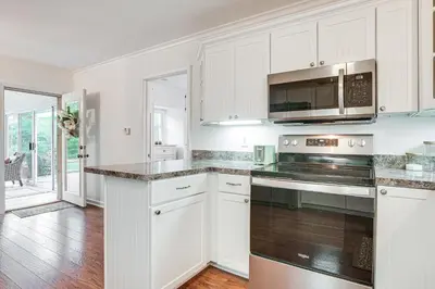a kitchen with white cabinets and stainless steel appliances at Thornville Home with Boat Dock On the Lake! in Hebron
