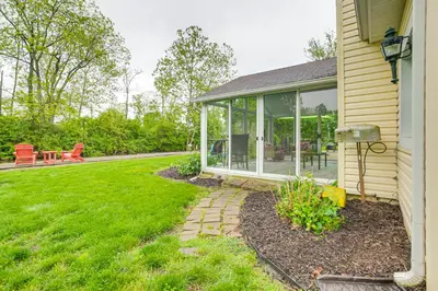 a house with a screened porch and a yard at Thornville Home with Boat Dock On the Lake! in Hebron