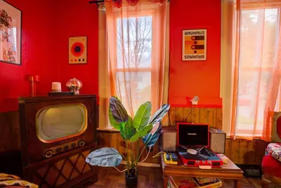 a living room with red walls and a tv at Retro 1970's Rollercoaster House 5 Mins from Cedar Point in Sandusky