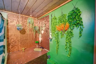a bathroom with a wall covered in green vines at Retro 1970's Rollercoaster House 5 Mins from Cedar Point in Sandusky