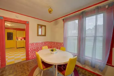 a dining room with a table and yellow chairs at Retro 1970's Rollercoaster House 5 Mins from Cedar Point in Sandusky