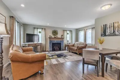 a living room with leather furniture and a fireplace at Four-Bedroom House in Lapel