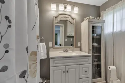 a bathroom with a sink and a mirror at Four-Bedroom House in Lapel