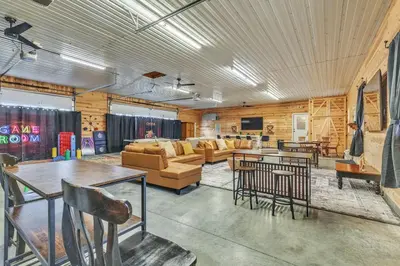 a living room with a couch and tables and chairs at Four-Bedroom House in Lapel