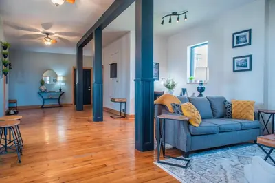 a living room with a blue couch and wooden floors at River City Loft in Portsmouth